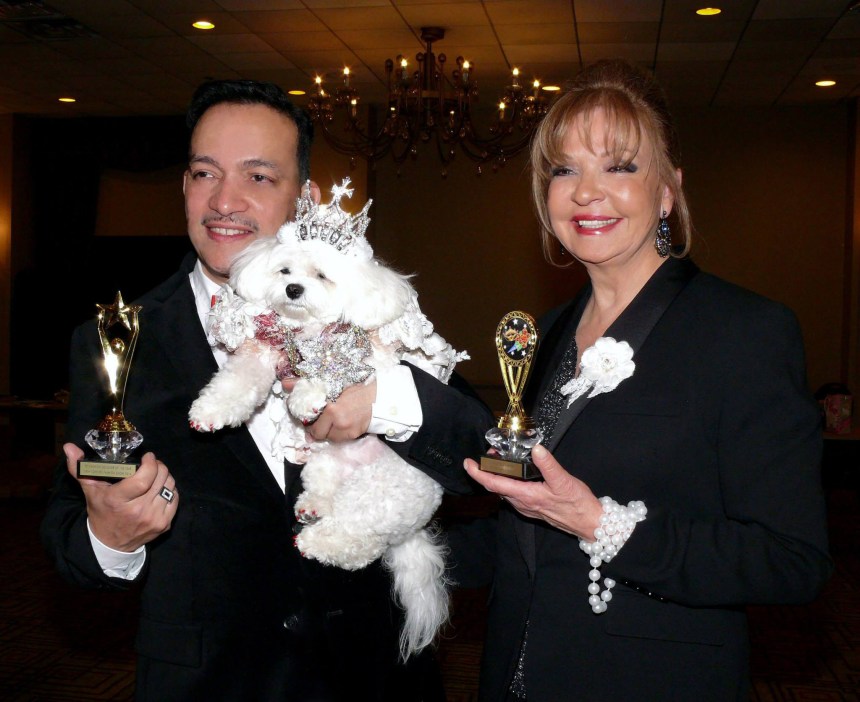Pet Couturier Anthony Rubio holding Maltese Bella Mia and Rose Ann Bolasny  after  being awarded the Designer Of The Year Award and Best Dressed Dog Award  at the New York Pet Fashion Show (Photo by Richard Alicea)